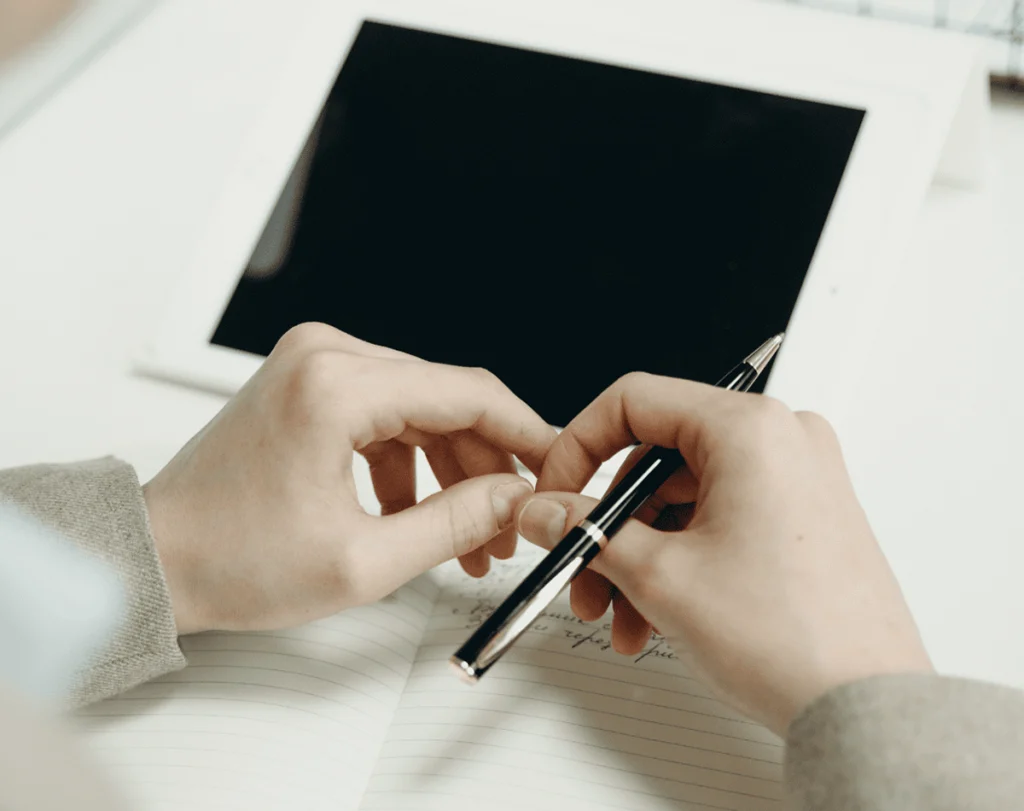 pessoa com lápis na mão, em frente ao computador